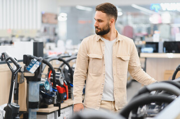 Customer choosing vacuum cleaner in electronics store