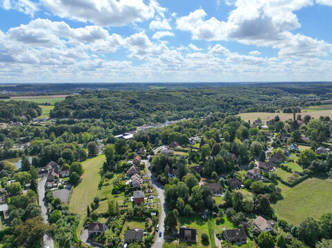 Aerial view of Genappe municipality and city of Wallonia located in the Belgian province of Walloon Brabant. Villas with garden surrounded by forest.