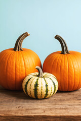 Obraz premium Halloween and Thanksgiving pumpkins on wooden surface with colourful autumn harvest still life teal background