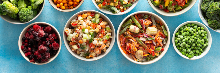 A top view of colorful, frozen vegetables on plates, highlighting the process of preserving summer best produce for nutritious winter meals, banner,, vegetables in plates on a blue background