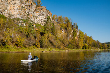 Enjoy a calming kayaking adventure on a peaceful river, surrounded by vibrant autumn leaves and majestic cliffs. Its the perfect escape from daily stress, immersing you in natures tranquil beauty © Aleksey