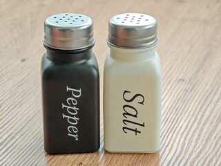 Classic salt and pepper shakers on a wooden table in a cozy dining setting
