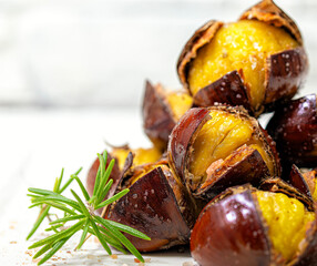 Roasted chestnuts in olive oil and pink salt. An autumn delicacy. White background.