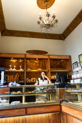 Smiling woman working in traditional bakery bread shop