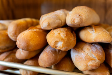 Freshly baked bread rolls stacking in bakery shop