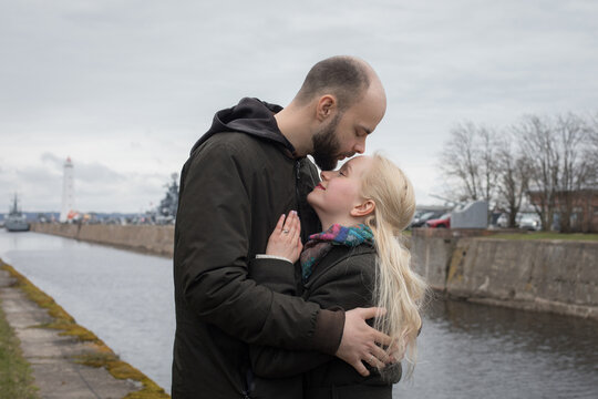 Romantic man and woman couple hugging each other kissing at seaside - Powered by Adobe
