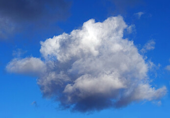 A Single, Fluffy White Cloud in a Deep Blue Sky on a Sunny Day