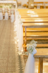 Floral wedding church pew decoration with roses, carnations and greenery