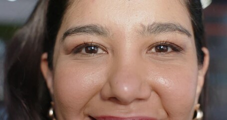 Camera focusing woman in room with hoop earrings, curling lips to smile blinking and widening smile - Powered by Adobe