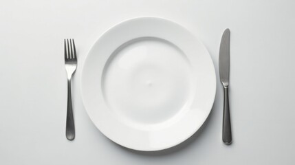 Simple Elegance A Pristine White Plate Set with Polished Silverware on a Smooth Surface