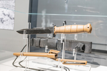 Collection of knives on display, arranged in clear plastic holders, indoors, varying sizes and materials wood, metal, synthetic No identifying marks Even lighting, neutral background, no people p