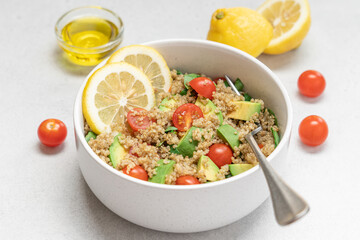 Healthy Quinoa Salad with Avocado and Tomatoes on White Plate