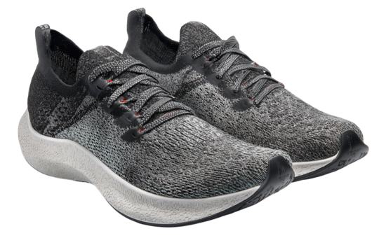 Pair of graphite knit running shoes with reflective thread and textured soles, isolated on transparent background.
