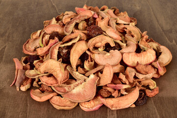 Organic dried fruits mix with apples, pears and plums on dark background