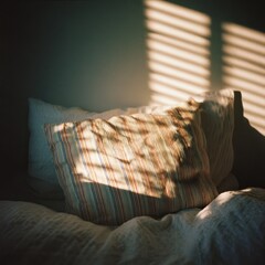 Sunlight streams onto a striped pillow