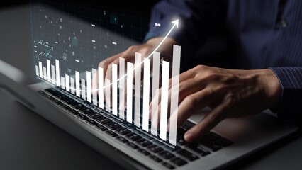 A close-up view of hands typing on a laptop with a graphical overlay of data trends and metrics, illustrating modern digital analysis and financial insights in a workspace. Copula