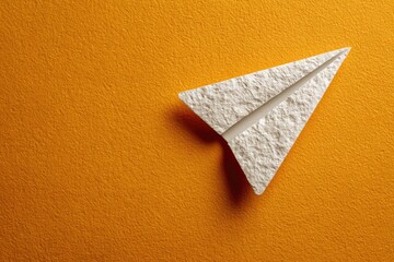Folded paper airplane on orange background