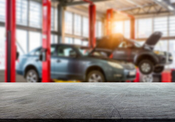 Cars being serviced in an auto shop with lifts and tools in the background during daytime