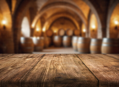 Wooden table in a winery cellar surrounded by barrels in soft lighting during the evening
