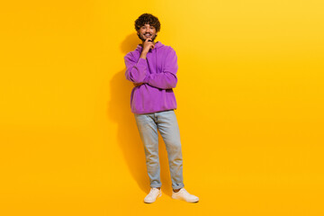 Fototapeta premium Cheerful Young man wearing a stylish hoodie smiling confidently against a bright yellow background