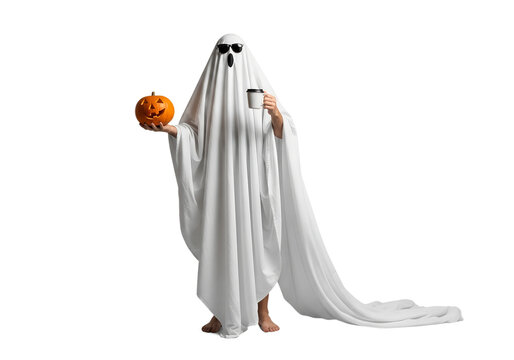 A man standing in a ghost costume made from a sheet with a pumpkin and coffee in sunglasses on an isolated background. Halloween celebration concept.