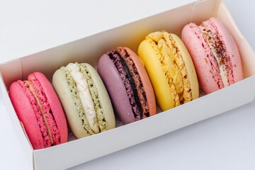 Colorful macarons displayed in a white box on a clean surface