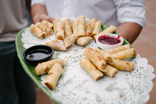 Bandeja de catering de boda con rollitos de primavera con salsas