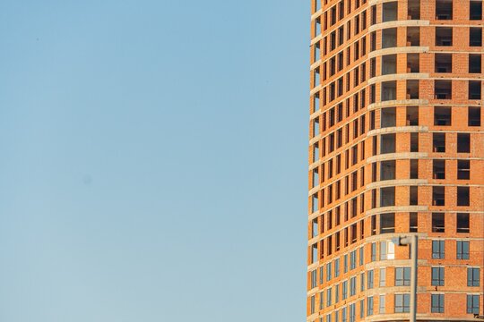 Modern, irregularly shaped windows, balconies, earth tones, overcast sky, diffused lighting, abstract architecture, muted colors, architectural capture, vertical lines a
