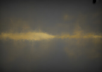 Naklejka premium Horizontal beam of golden light illuminating a dark, atmospheric sky through dense clouds.