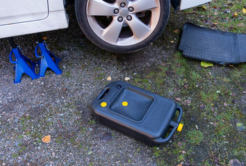 The car is prepared for an oil change, a canister for collecting old oil and a mat.