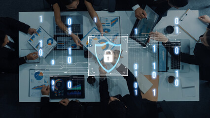 A diverse group of professionals collaborates in a modern office, discussing cybersecurity strategies with digital data overlays. Charts and analytics drive the conversation forward. Trope