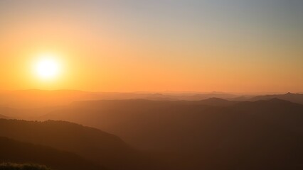 Fototapeta premium Golden sunrise over vast mountain peaks, creating a peaceful and expansive natural panorama.