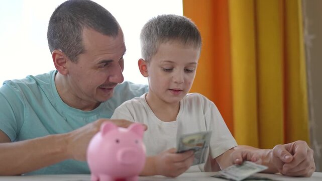 Boy holds dollar bills while father explains saving clearly. Money used again in lesson. Saving repeated as father builds strong habits. Family routine connects money to early finance learning