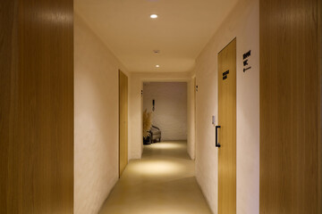 Modern Hotel Corridor Featuring Elegant Wooden Doors and Soft, Inviting Lighting Ambiance