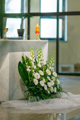 Elegant white wedding flower arrangement at church altar with hydrangeas and greenery