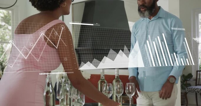 Woman arranging tablescape and activating business data charts while man pointing at graphs