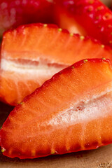 sliced red ripe strawberries, ripe sweet and juicy strawberries cut into pieces on a wooden table