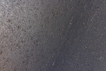 details of the black new asphalt on the highway, part of the newly built asphalt highway made of bitumen with crushed stone