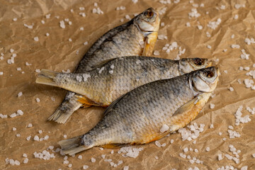 white salt and fish for long-term storage by dehydrating whole fish in the sun, dried fish in scales ready for human consumption, sprinkled with white salt crystals