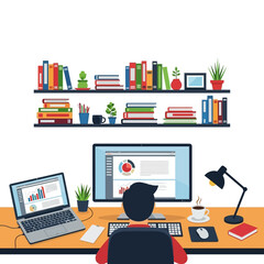 A person working at a desk with a laptop and desktop computer, surrounded by books and office supplies.