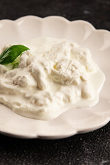 Stracciatella cheese soft young portion size Italian food natural product tasty snack fresh delicious gourmet food background on the table rustic top view copy space