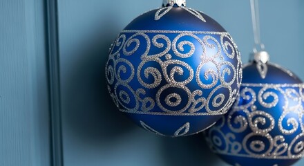 Festive blue ornaments with intricate silver glitter designs hanging nearby