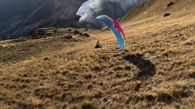 Paraglider point of view flight close to mountain terrain in New Zealand. Extreme sport action with high speed, risk, and aerial skill in dramatic outdoor landscape.