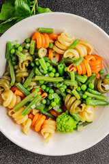 Trottole pasta vegetables green peas, green beans, kohlrabi cabbage, broccoli second course tasty snack fresh delicious gourmet food background on the table rustic food top view copy space
