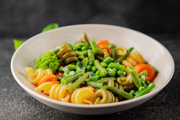 Trottole pasta vegetables green peas, green beans, kohlrabi cabbage, broccoli second course tasty snack fresh delicious gourmet food background on the table rustic food top view copy space