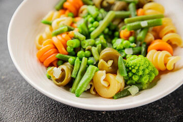 Trottole pasta vegetables green peas, green beans, kohlrabi cabbage, broccoli second course tasty snack fresh delicious gourmet food background on the table rustic food top view copy space