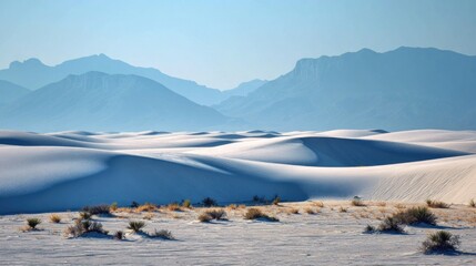 Obraz premium Vast white desert dunes meet hazy blue mountains