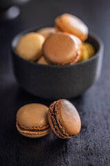 Different flavors of macarons. Colourful macaroons on black table.