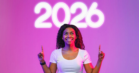 A cheerful young black female stands in a vibrant purple setting, pointing with both hands at a blank space above her. She exudes excitement, making it perfect for a promotional message.