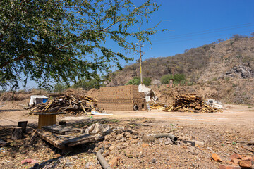 Kiln for firing of handmade bricks, pile of raw bricks drying in the sun, artesanal clay brick production. Guadalajara, Jalisco, March 29 2024.